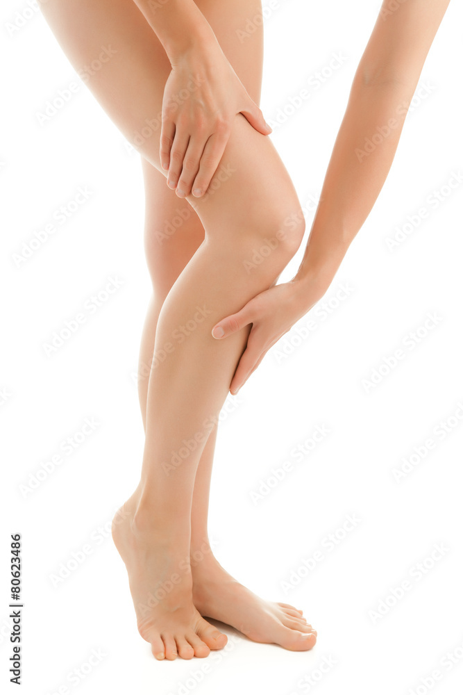 Woman massaging legs standing on white background Woman massaging legs standing on white background