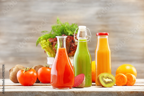Obraz Szklane butelki świeżego zdrowego soku z zestawem owoców i