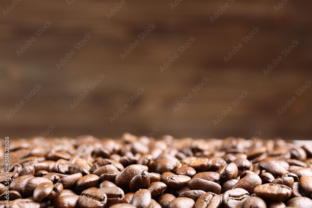 Naklejka premium Coffee beans on brown background