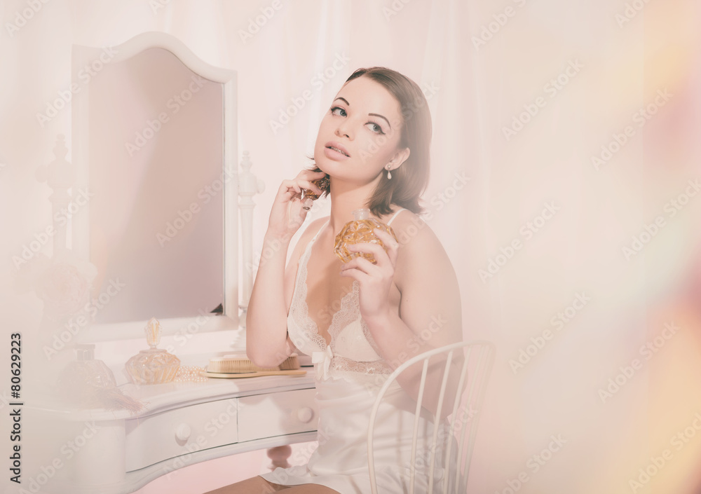 Sitting Young Woman in Nightdress Holding Perfume Sitting Young Woman in Nightdress Holding Perfume