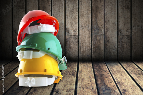 safety helmet and architect plant on wood background.
