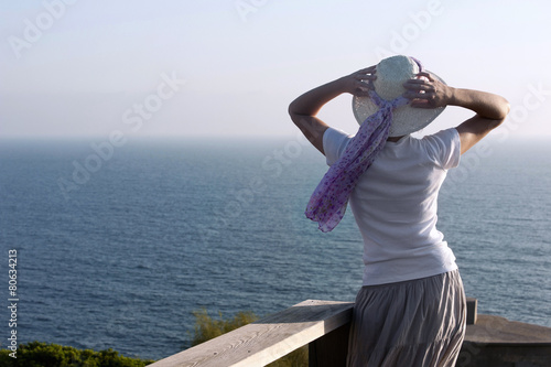 Woman of medium age  of backs  looking at the sea
