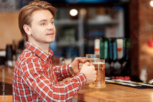 Young man with beer mugs