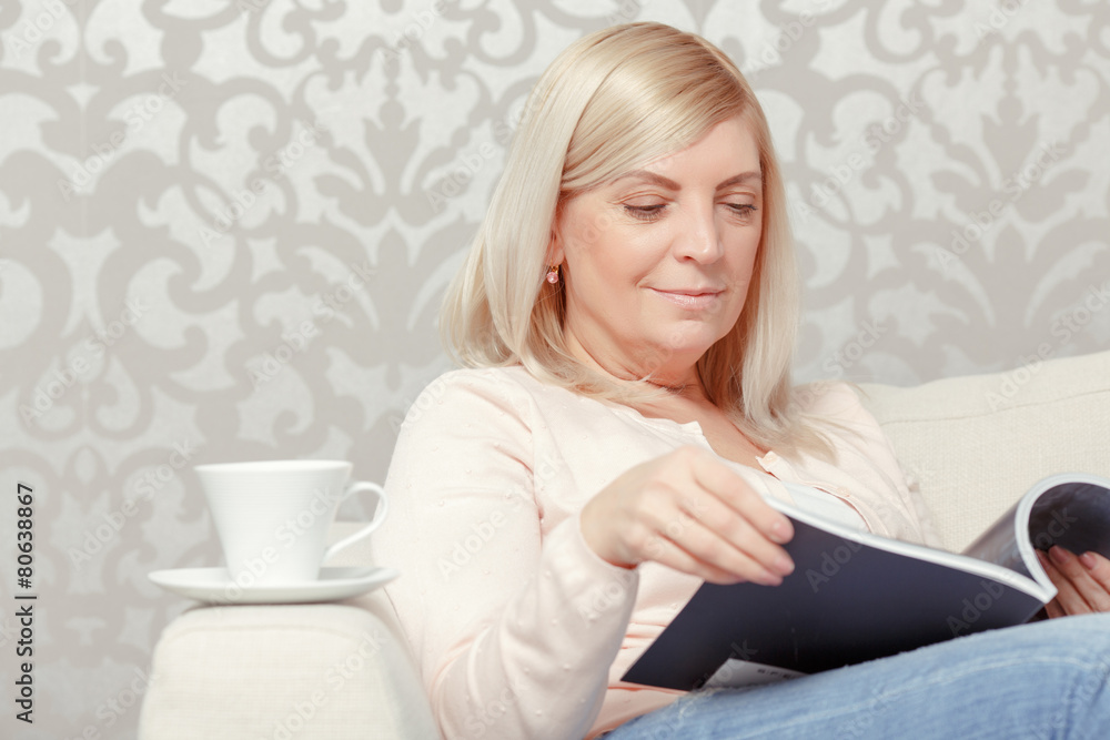 Woman reads magazine at home Woman reads magazine at home