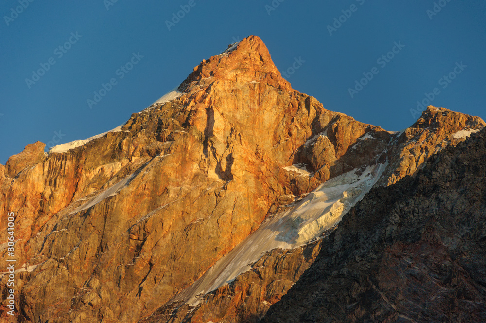 Hight scarlet mountain peak in sunset rays
