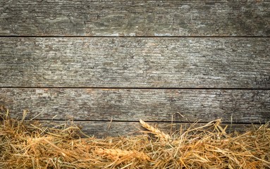 Straw and wheat on a rustic wooden background with copy space