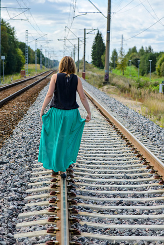 Young women walking on the rail track photo