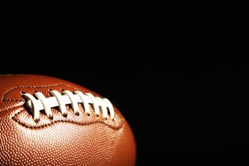 American football on green grass, on black background
