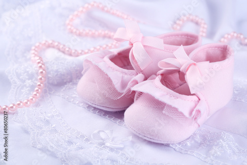 Pink baby boots on cloth close-up