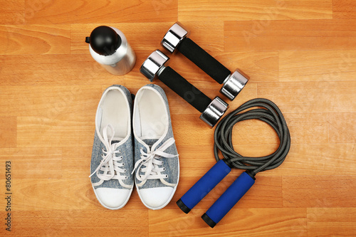 Shoes and sports equipment on wooden floor, top view