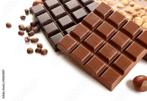 Chocolate bars with hazelnuts and coffee beans close up