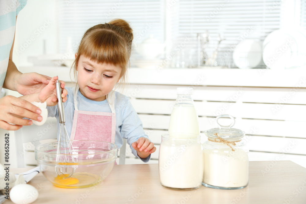 Little girl preparing cookies with mother in kitchen at home Little girl preparing cookies with mother in kitchen at home
