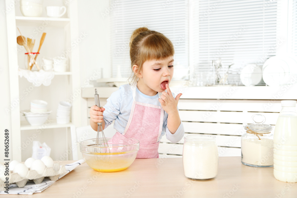 Little girl preparing cookies in kitchen at home Little girl preparing cookies in kitchen at home