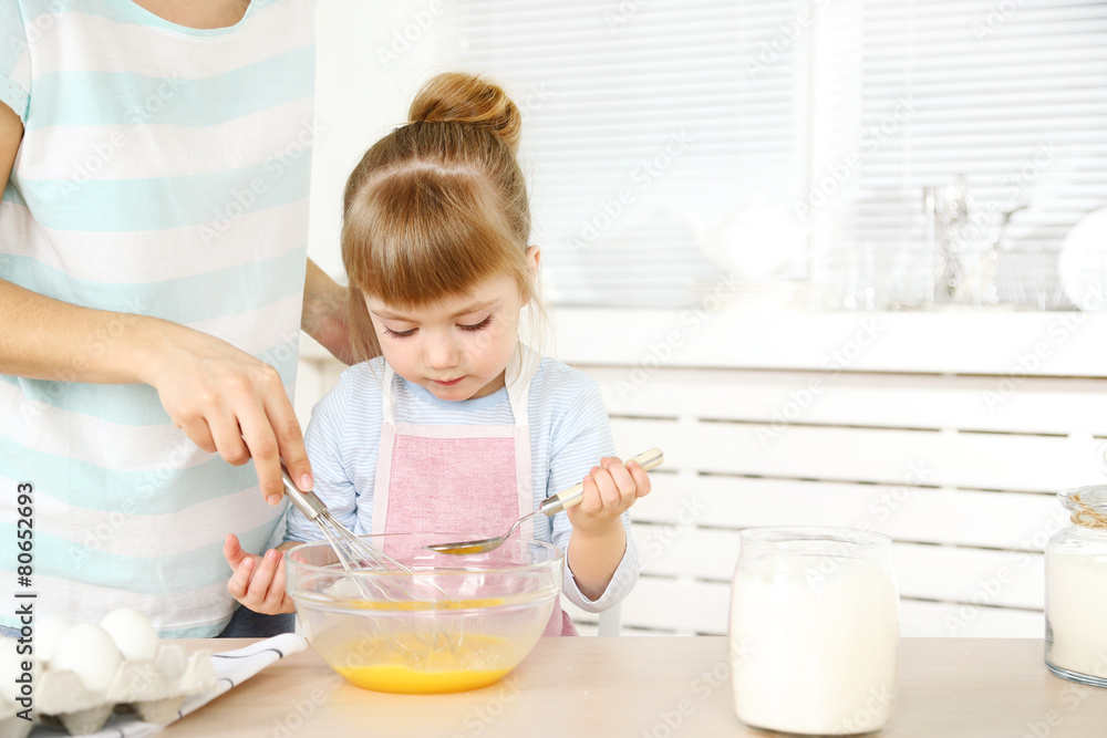 Little girl preparing cookies with mother in kitchen at home Little girl preparing cookies with mother in kitchen at home