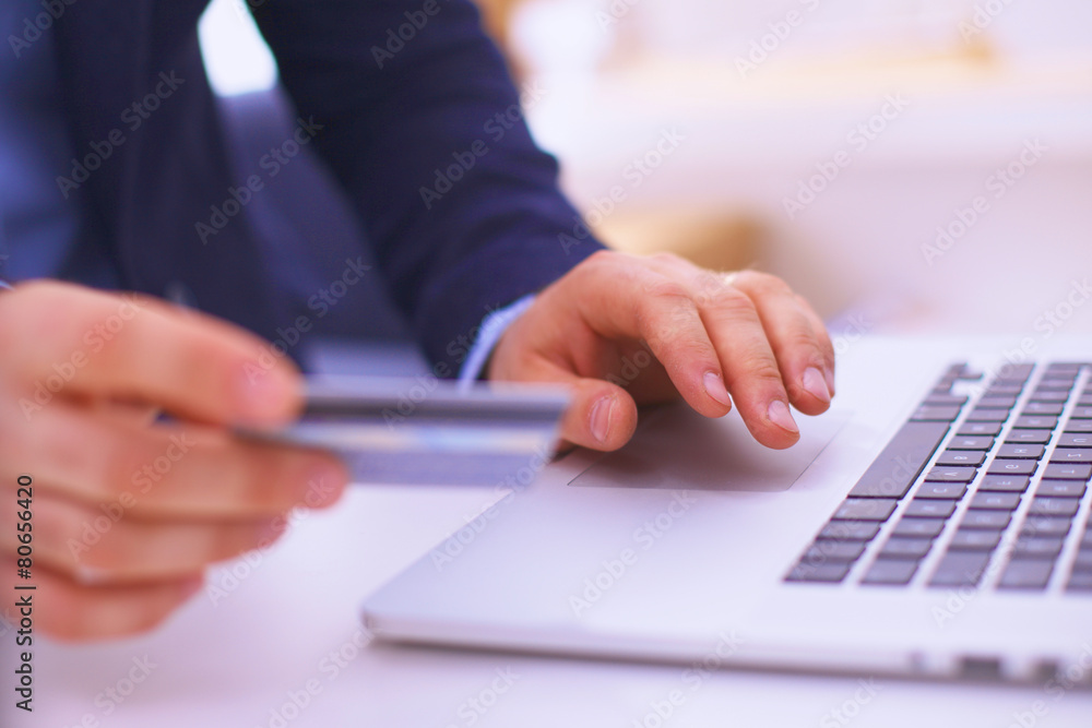 Businessman using his credit card for an online transaction Businessman using his credit card for an online transaction