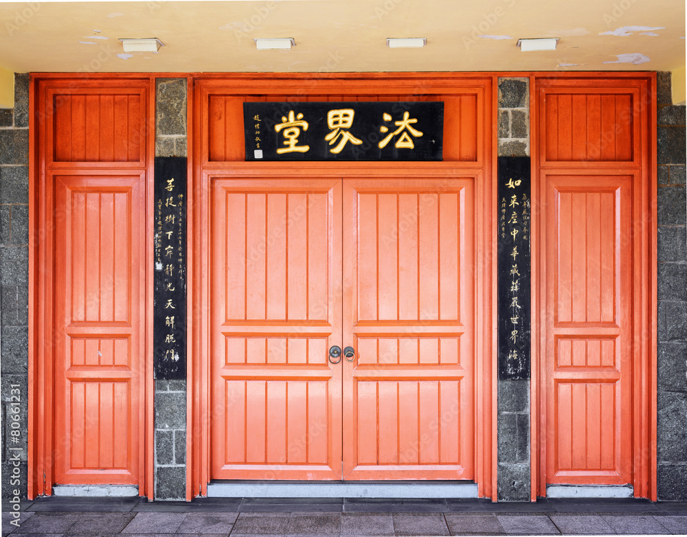 Red doors leading into a Buddhist temple located under the bronz