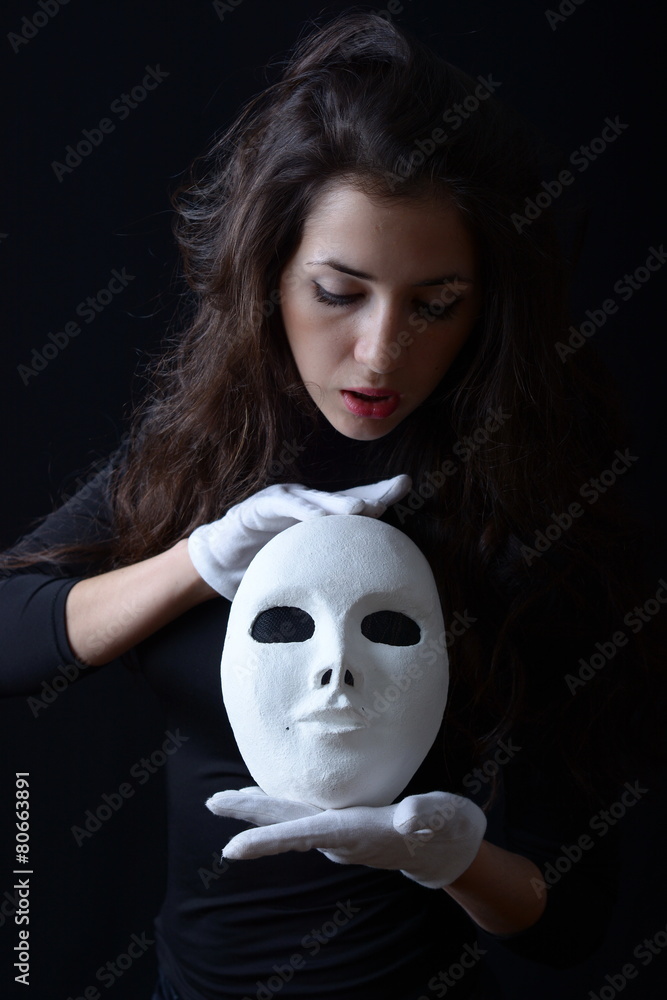 a brunette girl holding a white theatrical mask Stock Photo | Adobe Stock