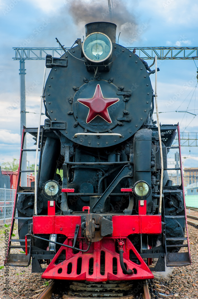 Naklejka premium old steam locomotive with smoke travels on rails