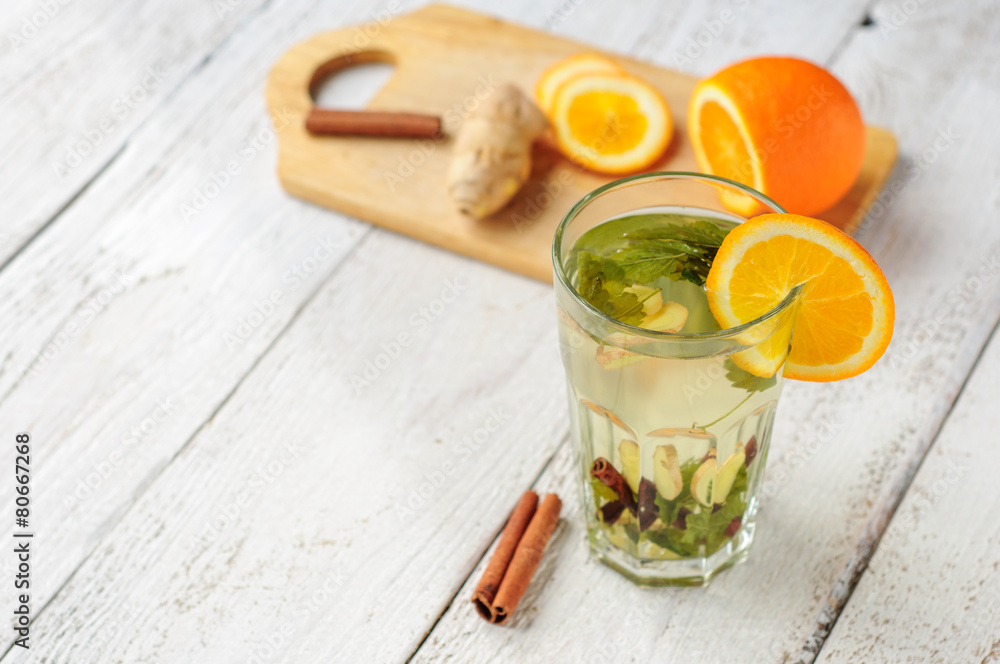 Fototapeta premium Herbal tea with orange and ginger in glass