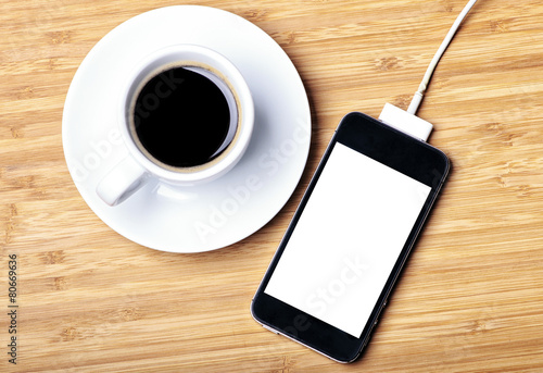 Rechargeable smartphone and a cup of espresso