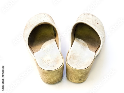 Old white woman clogs on white background seen from the heel