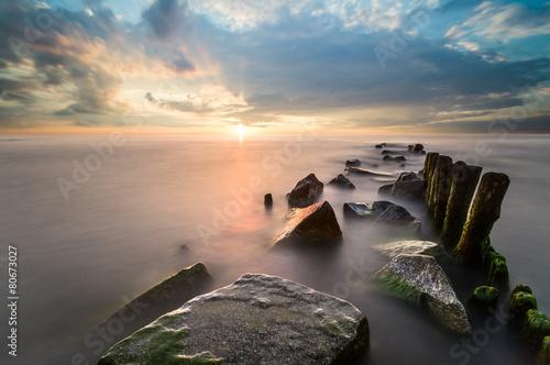 Zachód słońca nad morskim falochronem photo