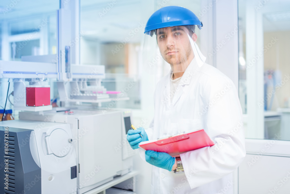 Scientist using protective rubber gloves and helmet Scientist using protective rubber gloves and helmet