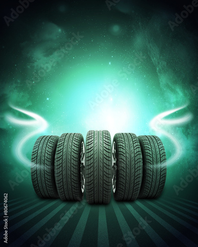 Wedge of new car wheels. Background is night sky and stripes at