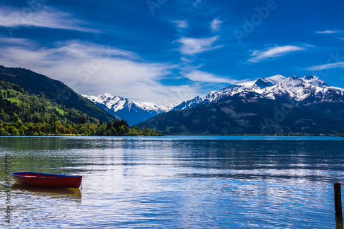 Zeller See mit rotem Ruderboot und Hohe Tauern