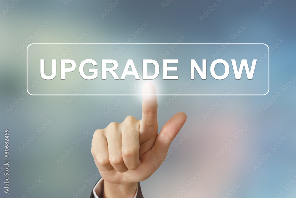 business hand clicking upgrade now button on blurred background business hand clicking upgrade now button on blurred background