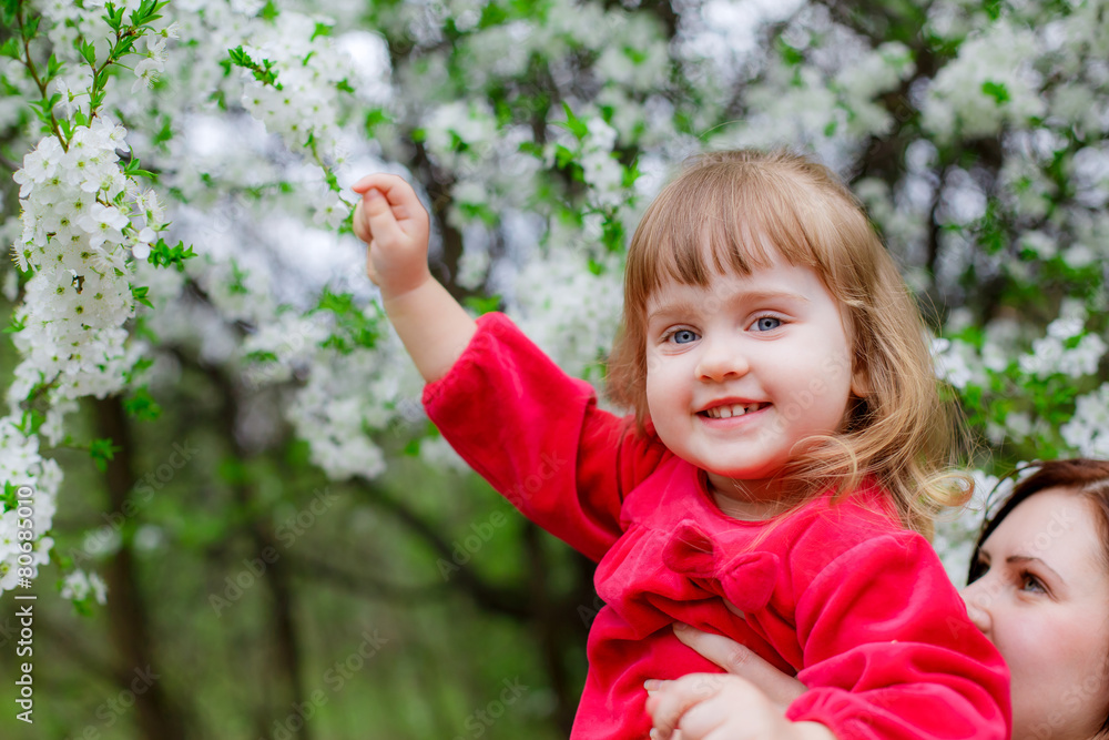 Adorable little girl in a flowered garden