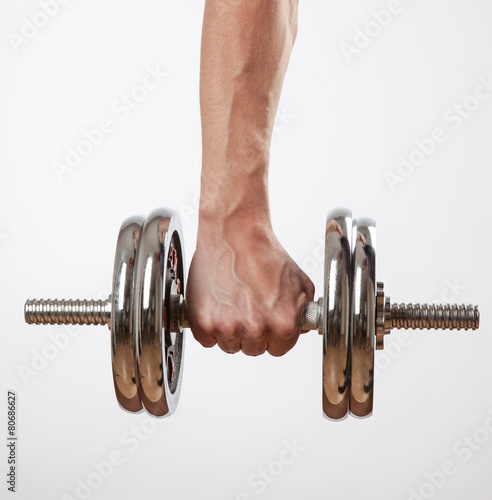 Hand holding chrome dumbbell on the white background.