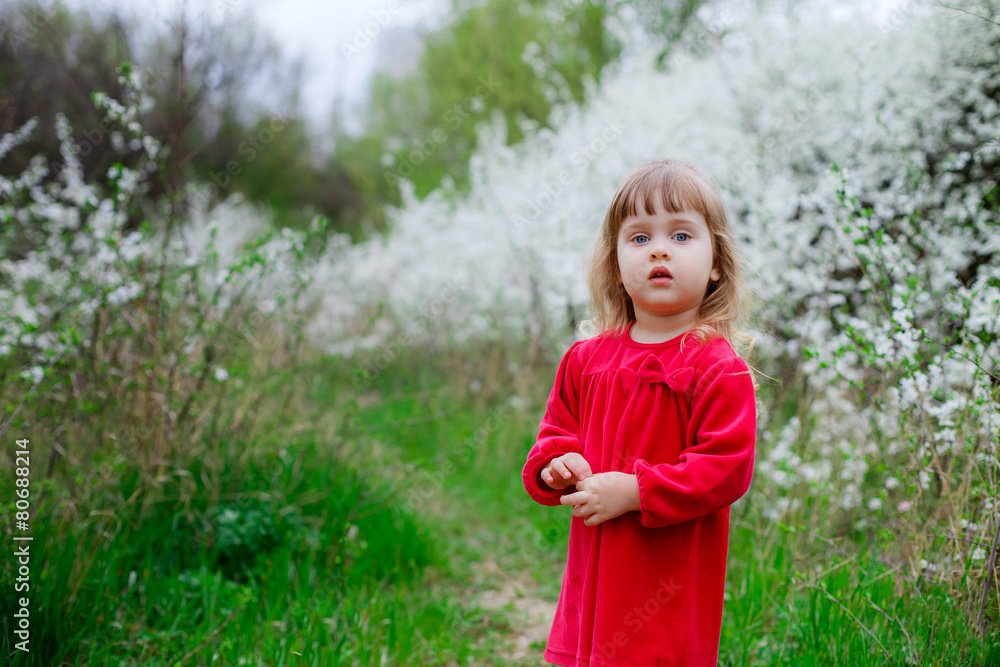 Adorable little girl in a flowered garden Adorable little girl in a flowered garden