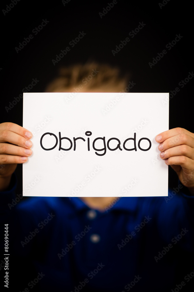 Child holding sign with Portuguese word Obrigado - Thank You Child holding sign with Portuguese word Obrigado - Thank You