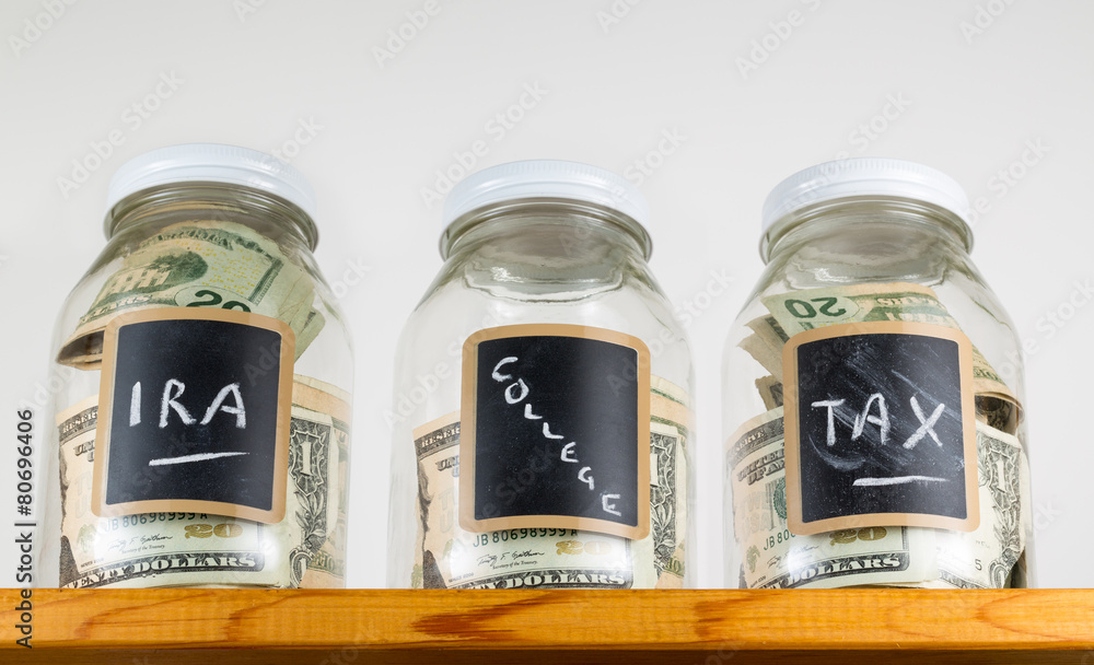 Three glass jars on wooden shelf for savings Three glass jars on wooden shelf for savings