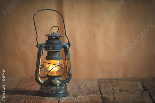 vintage kerosene oil lantern lamp burning with a soft glow light photo