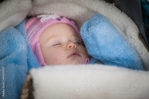 Sleeping baby lying in the stroller. Peaceful infant girl
