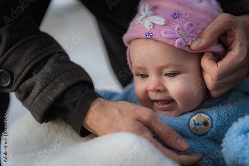 Smiling baby sitting in sledge. Happy infant girl while Hiking