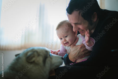 Image of young dad with cute little daughter in his arms