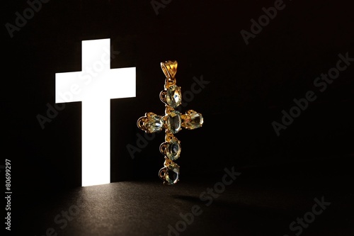 Golden Cross with gemstone jewel on black background