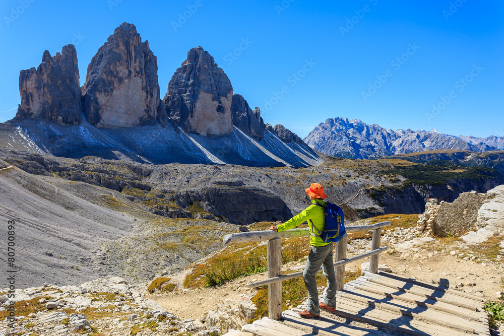 Woman tourist looking at Tre Cime peaks in Dolomites Mountains