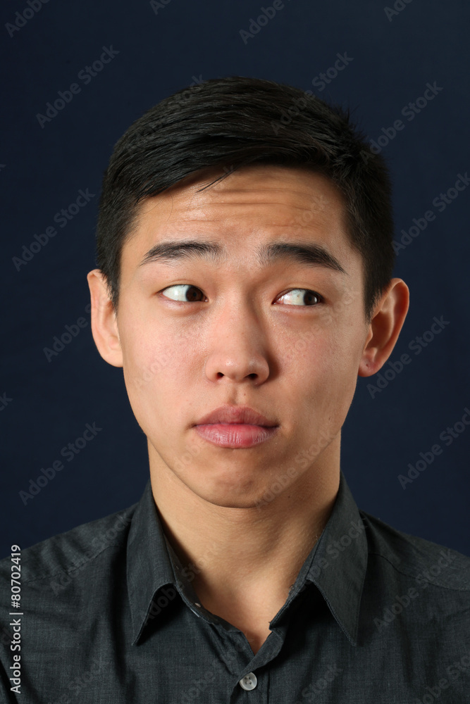 Young Asian man looking sideways Young Asian man looking sideways