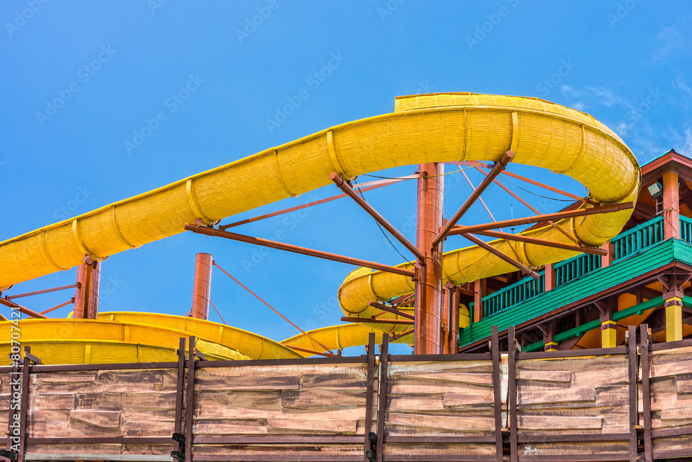The yellow water slider at outdoor amusement park The yellow water slider at outdoor amusement park