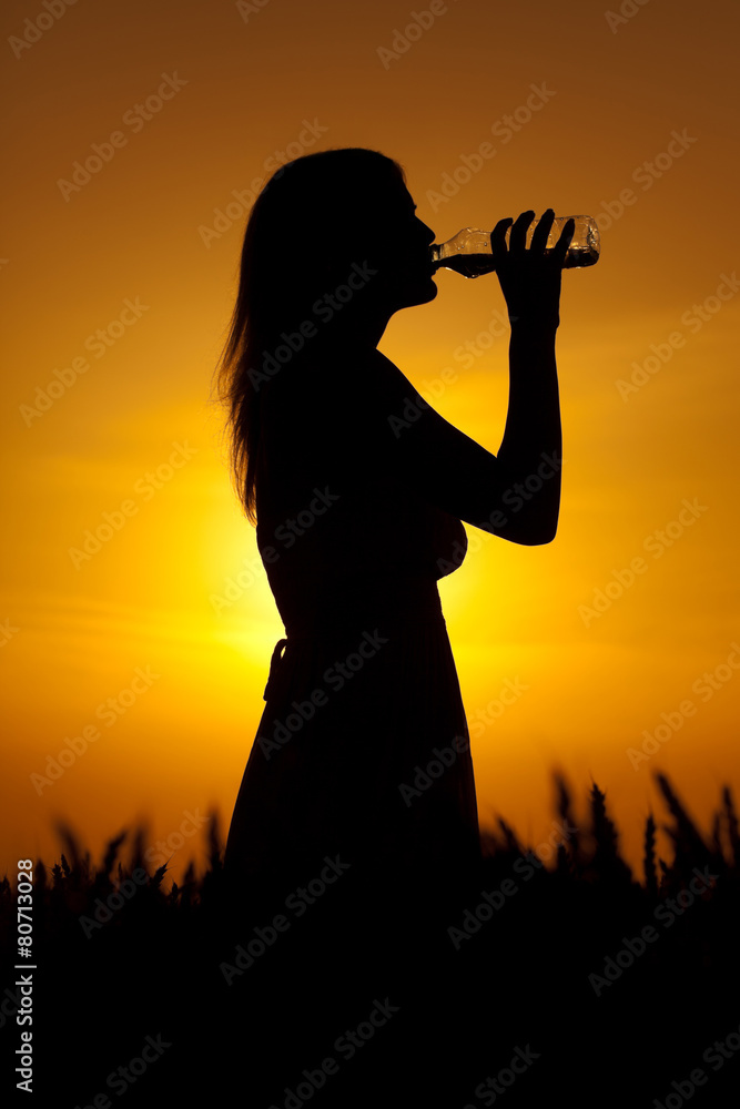 Silhouette of woman drinking water