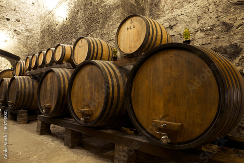 Wine barrels stacked in the old cellar of the winery. photo