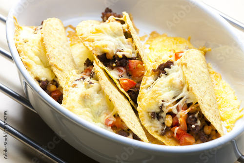 baked tacos filled with minced beef meat, beans and tomatoes