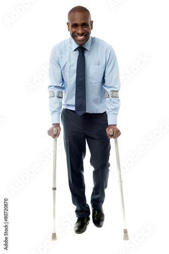 Middle aged man walking with two crutches