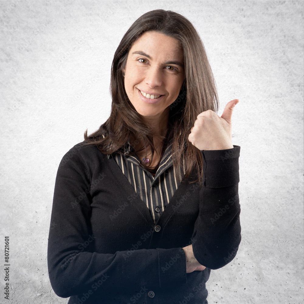 Beautiful adult girl doing an OK gesture over white background