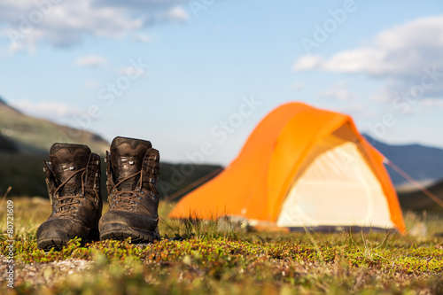 hiking boots in front of a tent