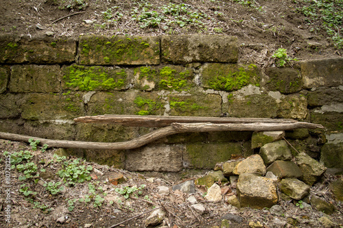 retaining wall of stone limestone overgrown with moss